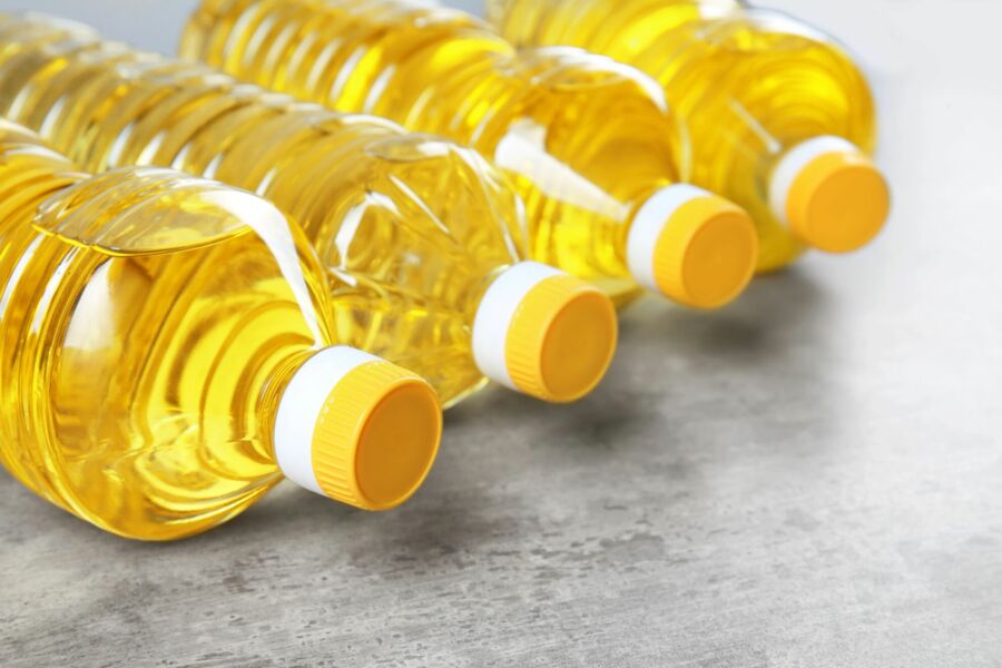 Vier liegende Flaschen Rapsöl